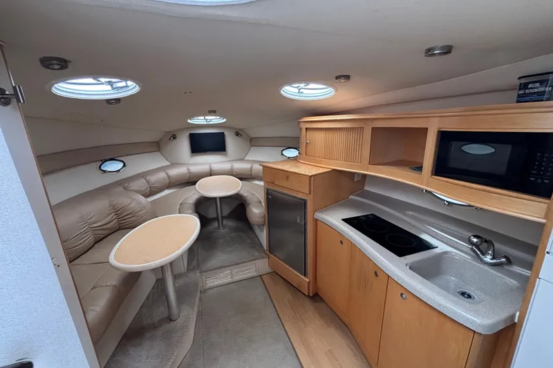 Interior of a 2004 Larson 310 boat with kitchenette and seating area.