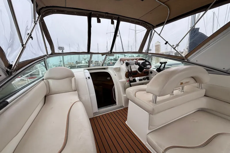 Interior of a 2004 Larson 310 boat with beige seating and wooden flooring.