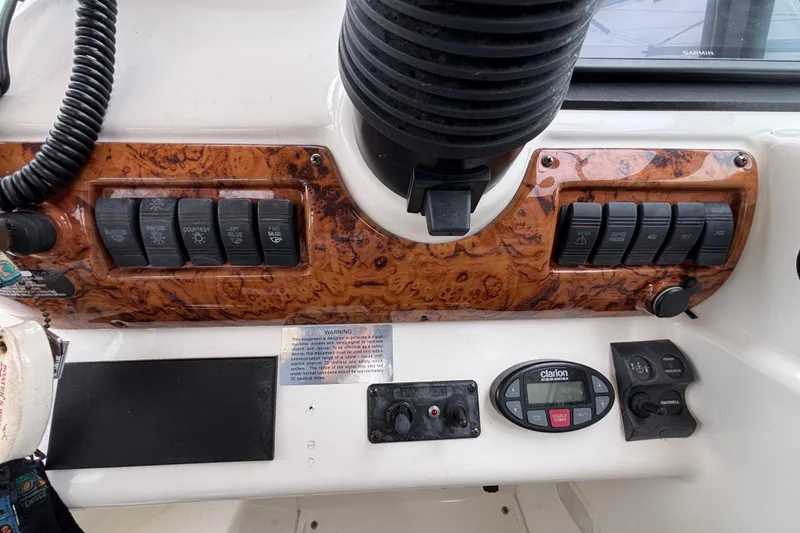 Control panel of a 2004 Larson 310 boat with switches and dials.