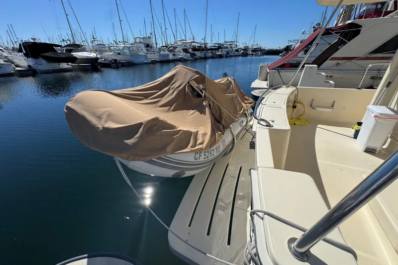 2006 Mainship 34 Trawler docked at marina with covered dinghy.