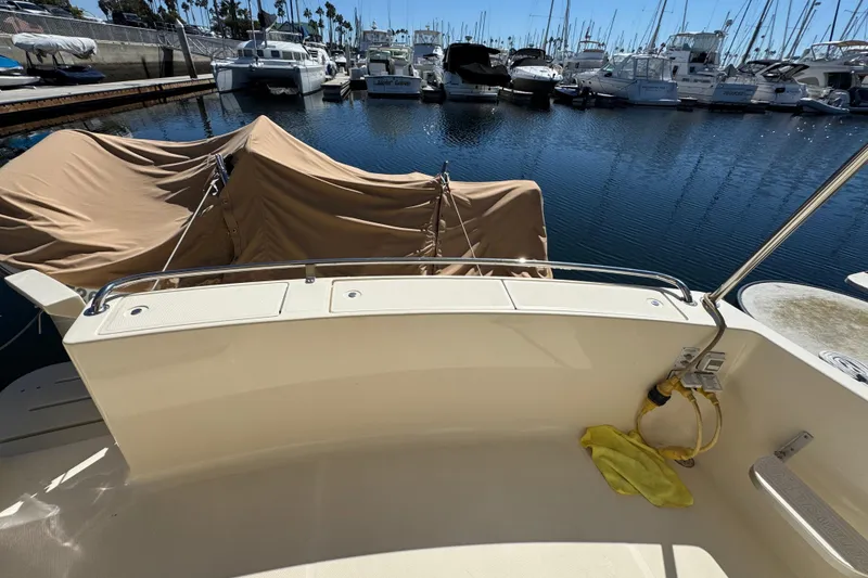 2006 Mainship 34 Trawler docked at marina, covered equipment, sunny day.
