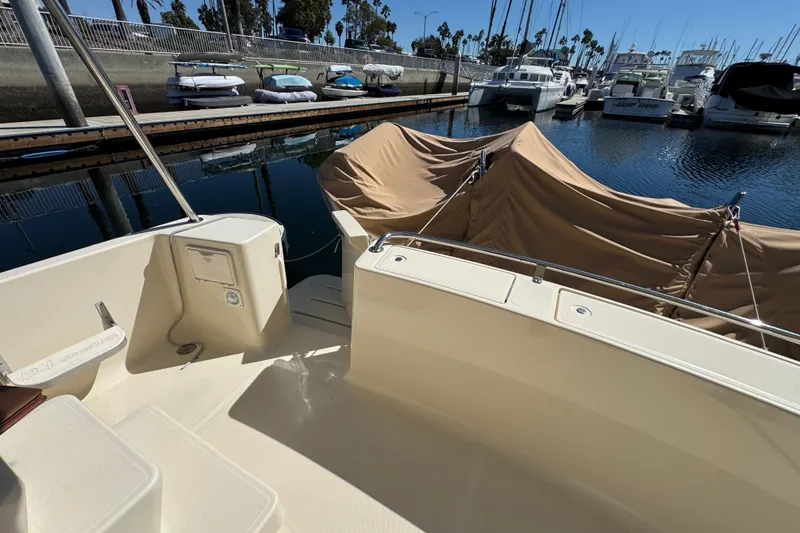 2006 Mainship 34 Trawler docked, featuring covered seating area and marina view.