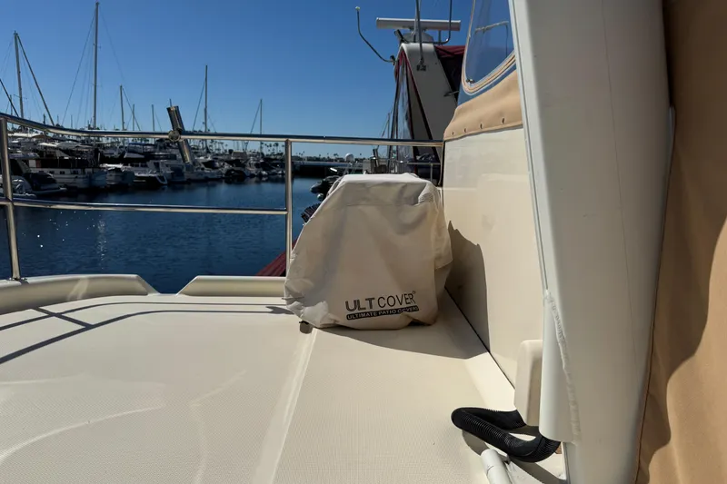 2006 Mainship 34 Trawler deck with marina view, featuring protective cover.