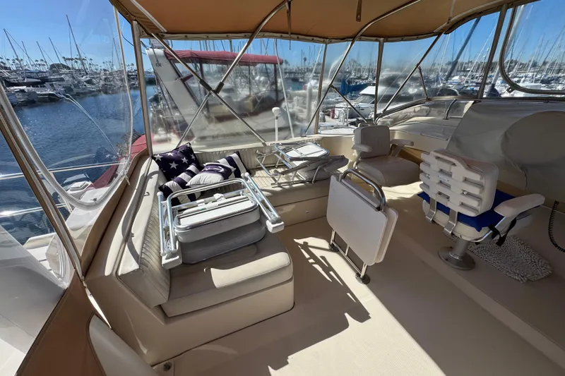 2006 Mainship 34 Trawler interior with seating, helm, and marina view.