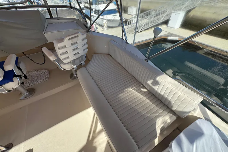 2006 Mainship 34 Trawler interior with seating and helm, docked at marina.
