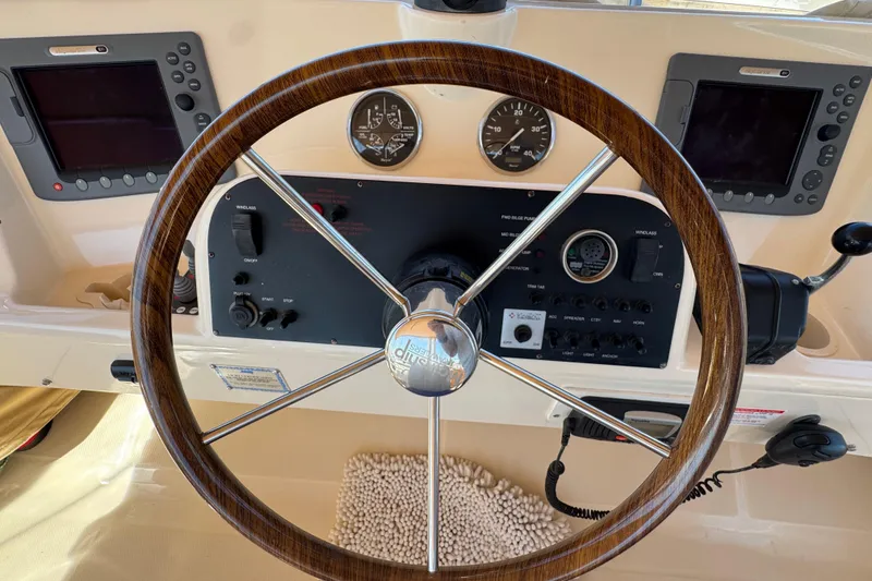 Steering wheel and dashboard of 2006 Mainship 34 Trawler with navigation instruments.
