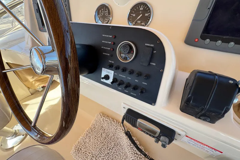 2006 Mainship 34 Trawler helm with wooden steering wheel and control panel.