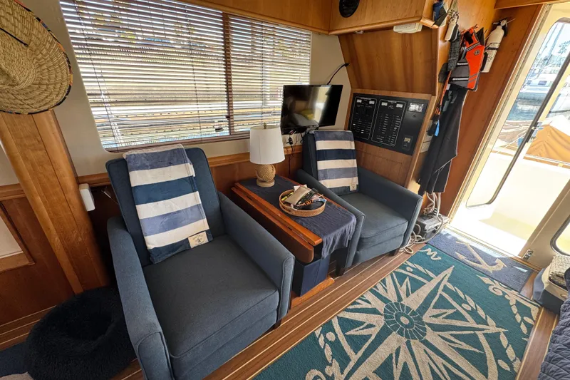 Interior of 2006 Mainship 34 Trawler with cozy seating and nautical decor.