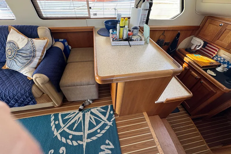 Interior of 2006 Mainship 34 Trawler with cozy seating and nautical decor.
