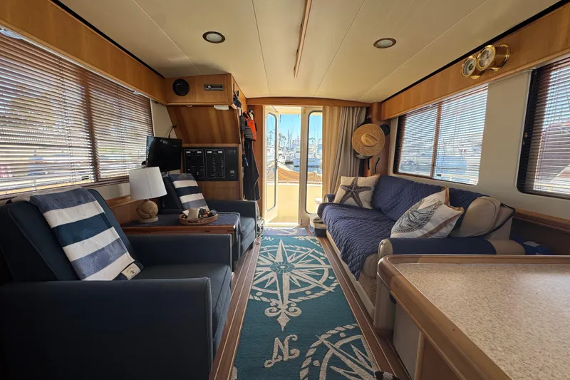 Interior of 2006 Mainship 34 Trawler with cozy seating and nautical decor.