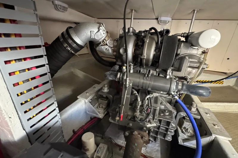 Engine room of a 2006 Mainship 34 Trawler, showcasing mechanical components and piping.