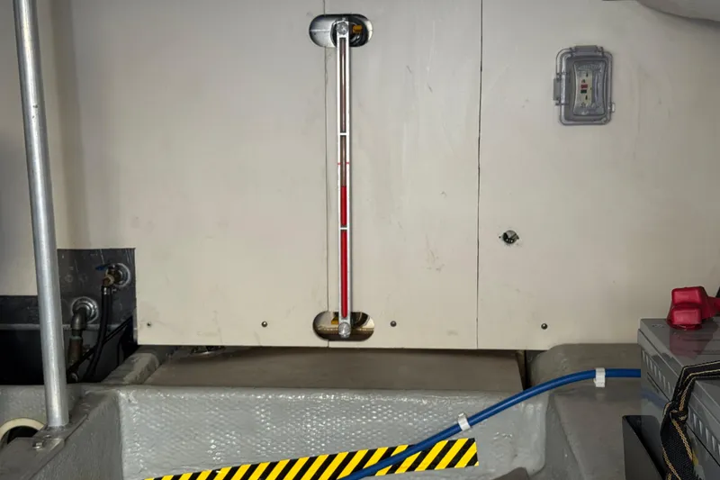 Engine room of 2006 Mainship 34 Trawler with visible gauge and wiring.