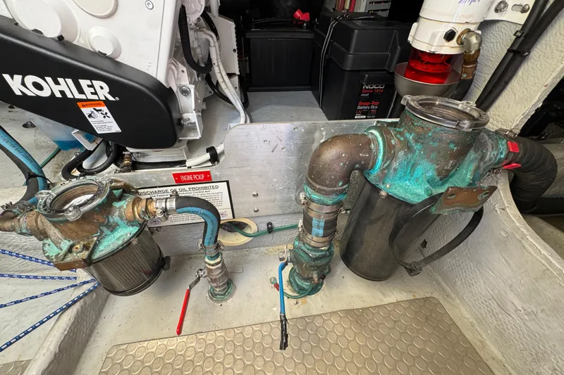 Engine room of 2006 Mainship 34 Trawler with Kohler generator and plumbing components.