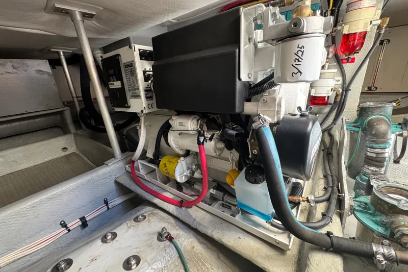 Engine room of 2006 Mainship 34 Trawler, showcasing mechanical components and wiring.