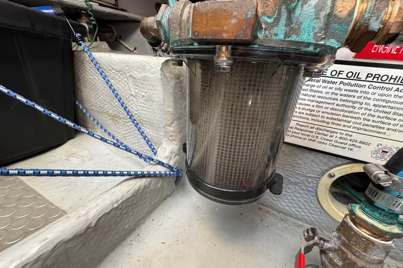 Engine compartment of 2006 Mainship 34 Trawler with visible filter and ropes.