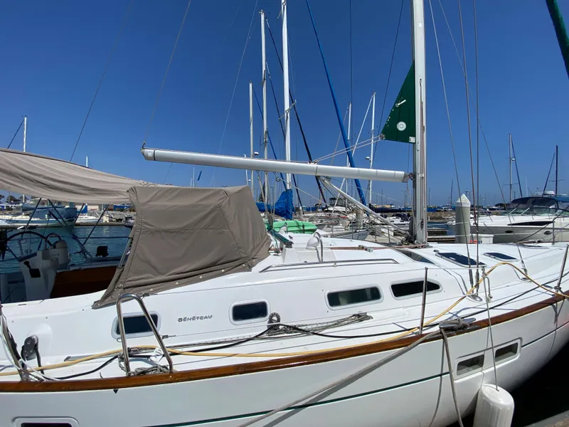 2003 Beneteau 423 sailboat docked in a marina under a clear blue sky.