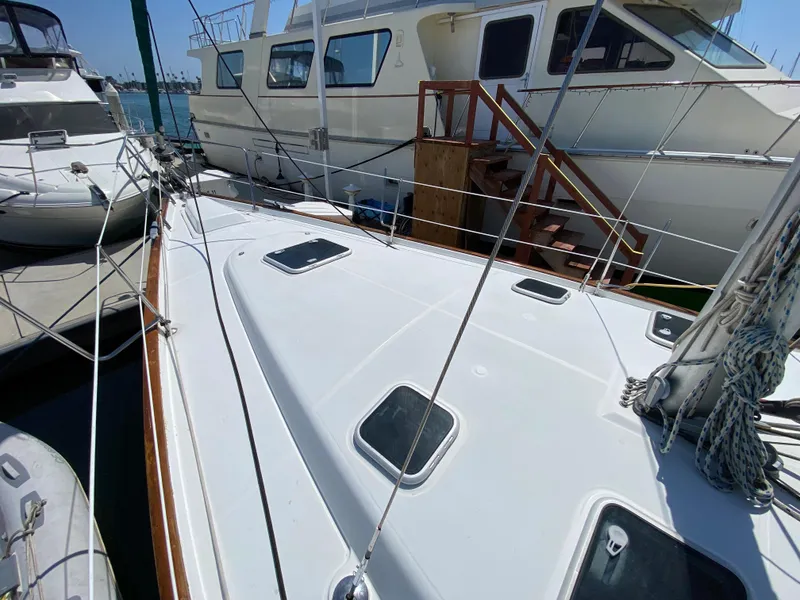 2003 Beneteau 423 sailboat deck view at marina, surrounded by other boats.