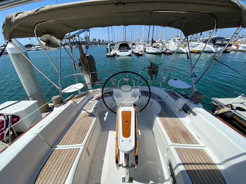 2003 Beneteau 423 sailboat cockpit with steering wheel, docked at marina.