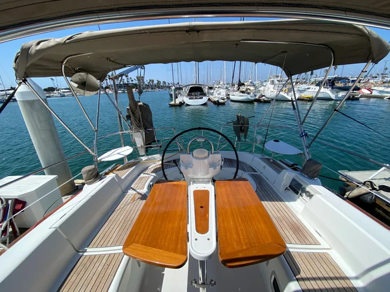 2003 Beneteau 423 sailboat cockpit with wooden table, docked at marina.