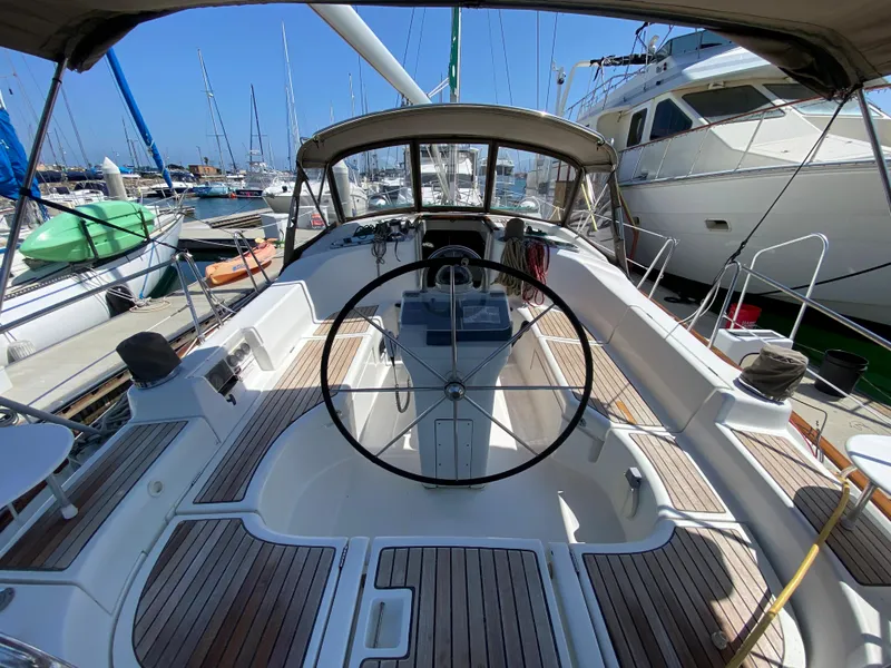 2003 Beneteau 423 sailboat cockpit with steering wheel, docked at marina.