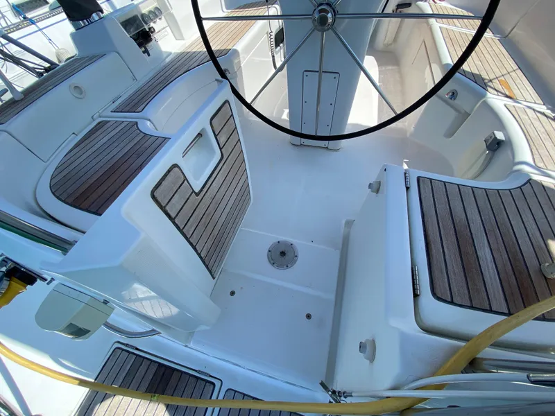 Cockpit of 2003 Beneteau 423 sailboat with teak seating and steering wheel.