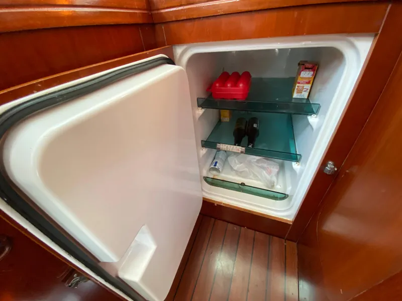 Open fridge inside 2003 Beneteau 423 yacht, showing shelves with various items.
