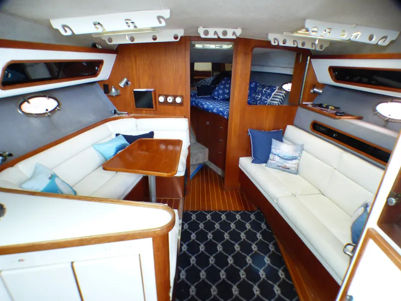 1989 Tiara Yachts 3300 interior with wood accents, white seating, and nautical decor.