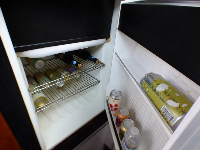 Mini fridge stocked with beverages inside a 1989 Tiara Yachts 3300.