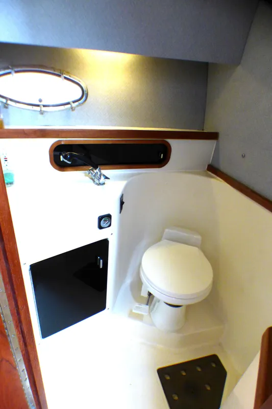 1989 Tiara Yachts 3300 bathroom interior with toilet and porthole window.