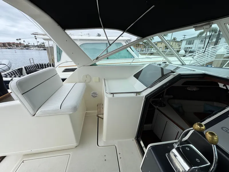 1989 Tiara Yachts 3300 cockpit with seating, steering wheel, and marina view.