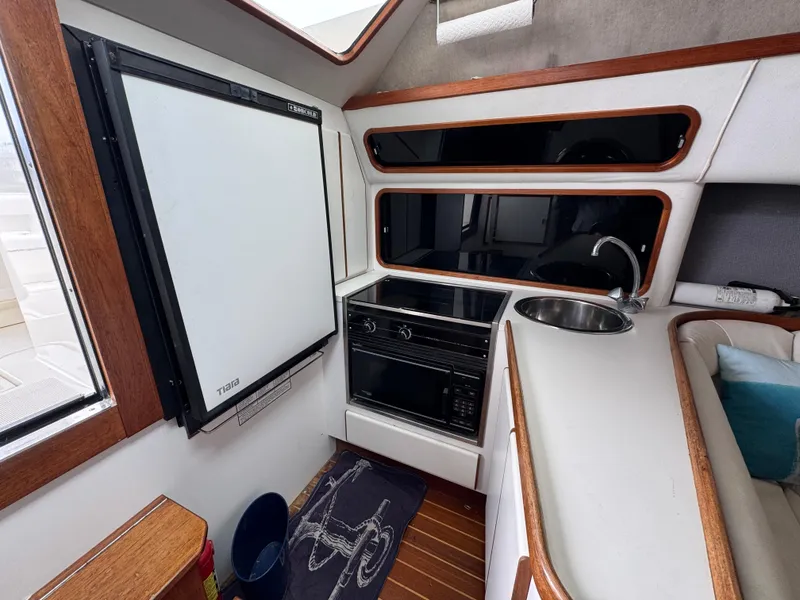 1989 Tiara Yachts 3300 interior kitchen with fridge, stove, and sink.