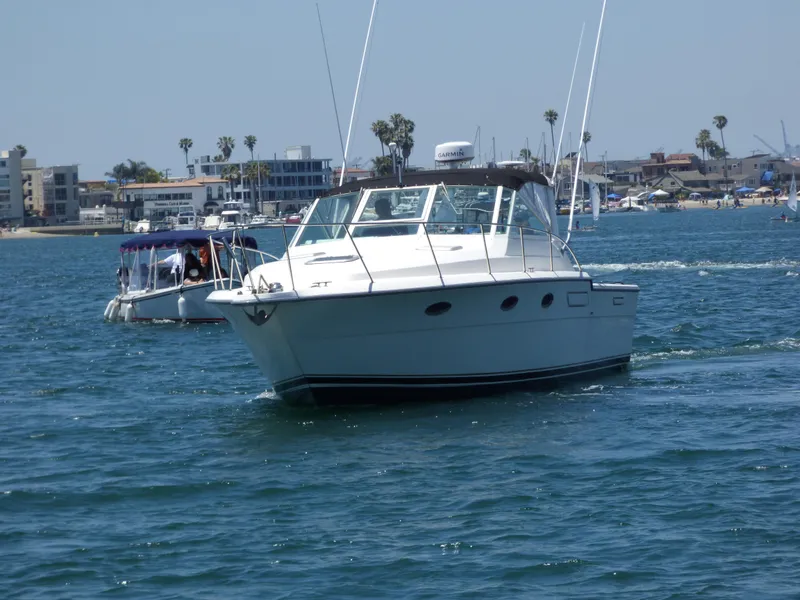 1989 Tiara Yachts 3300 cruising on a sunny day in a coastal harbor.