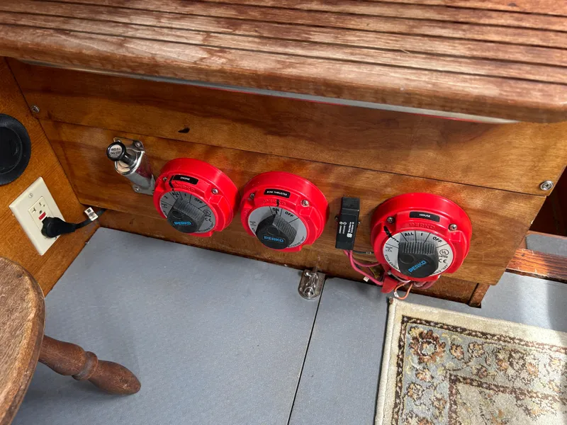 Control panel of a 1975 Fisher 30 Motorsailer with red dials and wooden finish.