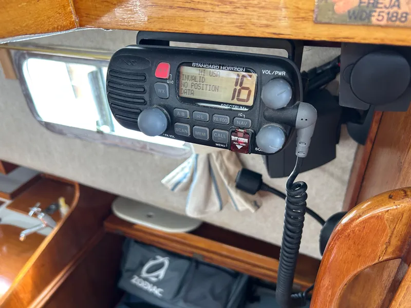 VHF radio on 1975 Fisher 30 Motorsailer, displaying channel 16 in a wooden cabin interior.