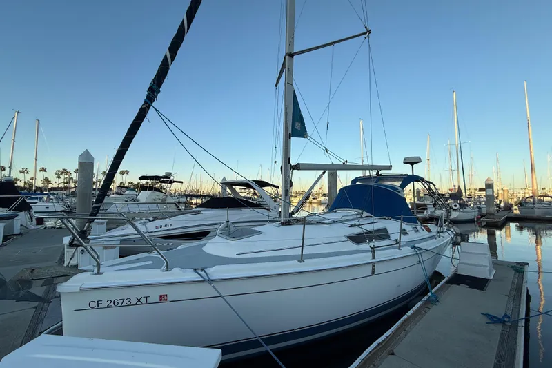 2007 Hunter 31 sailboat docked at marina during sunset.
