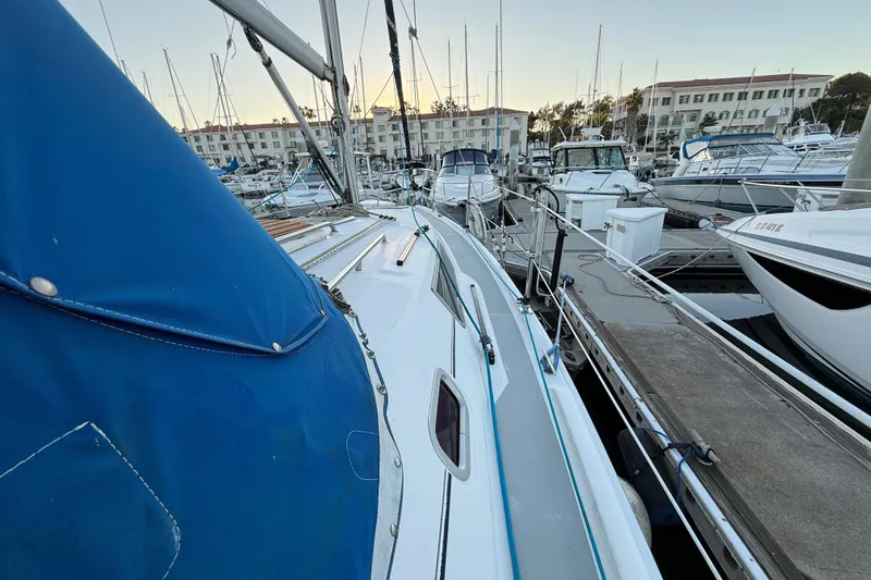 Sailboat docked in marina, Hunter 31 model, 2007, with blue cover.