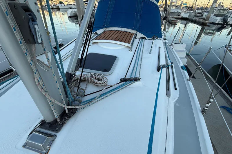 Sailboat deck of 2007 Hunter 31, featuring rigging and blue canopy in marina setting.