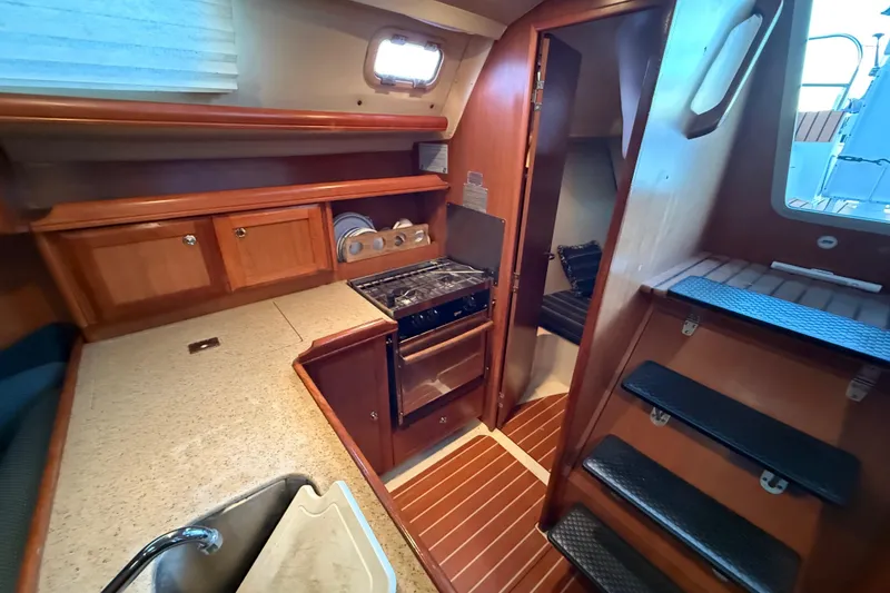 Interior of 2007 Hunter 31 sailboat with kitchen and wooden cabinetry.