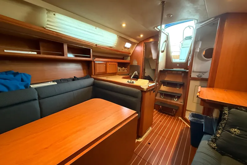 Interior of a 2007 Hunter 31 sailboat with wooden furnishings and cozy seating.