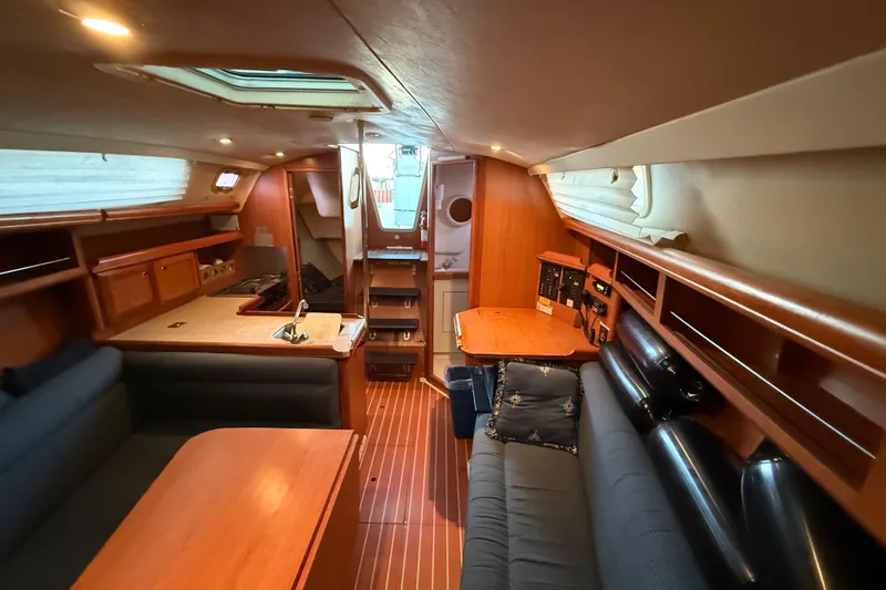 Interior of 2007 Hunter 31 sailboat with wood finish and cozy seating area.