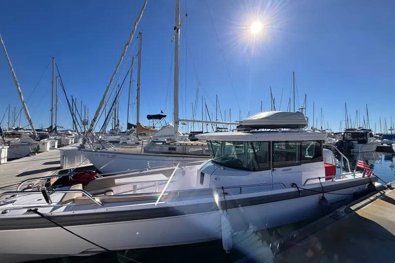 2022 Axopar 28 AFT CABIN boat docked in a sunny marina with sailboats.