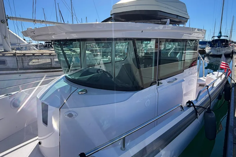 2022 Axopar 28 AFT CABIN boat docked in a marina under clear blue skies.