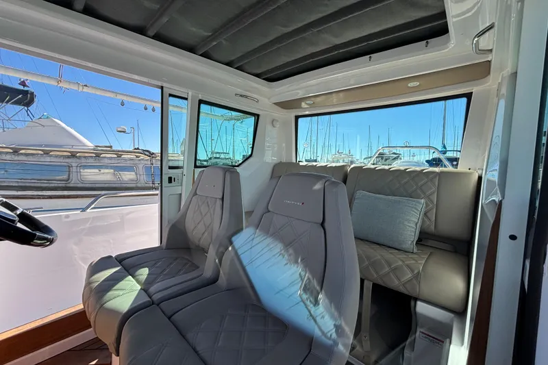 Interior of 2022 Axopar 28 AFT CABIN with luxurious seating and marina view.