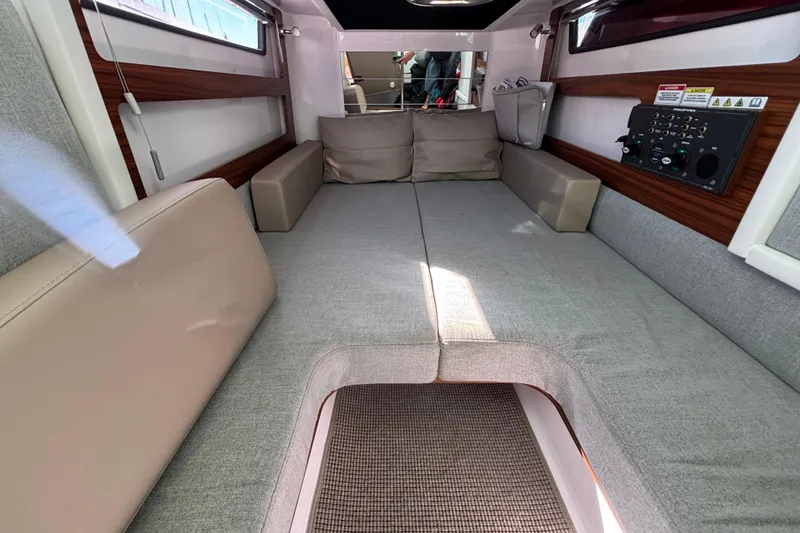 2022 Axopar 28 AFT CABIN interior with cozy seating and control panel.