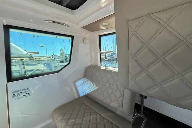 Interior of 2022 Axopar 28 AFT CABIN with quilted seating and marina view.