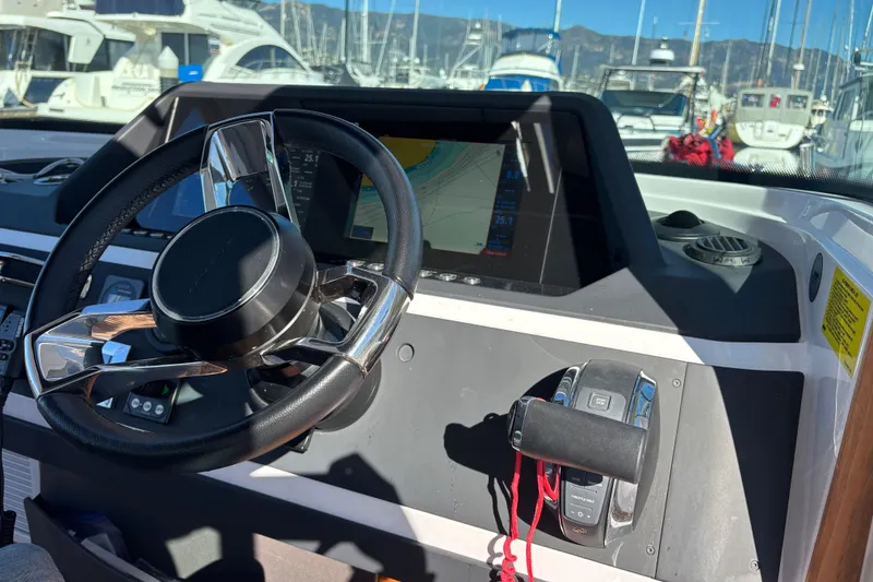 2022 Axopar 28 AFT CABIN helm with steering wheel and navigation display.