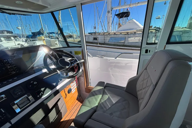 Interior view of 2022 Axopar 28 AFT CABIN boat with helm and seating.