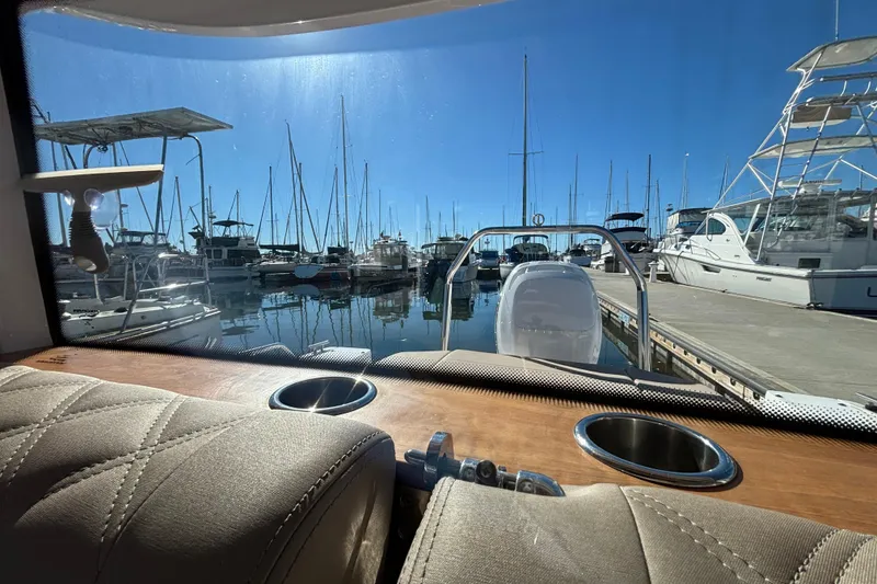 Interior view from 2022 Axopar 28 AFT CABIN, overlooking marina with docked boats.
