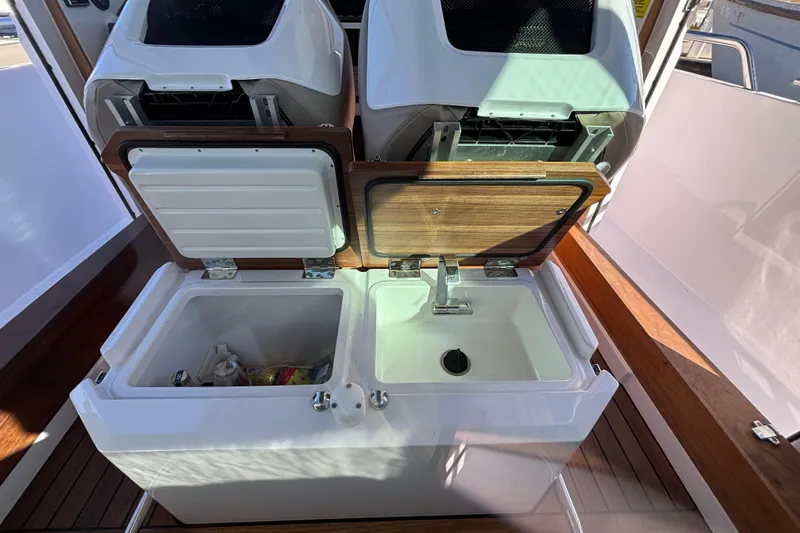 2022 Axopar 28 AFT CABIN interior with open storage compartments and sink.