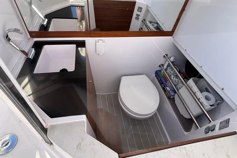 2022 Axopar 28 AFT CABIN bathroom with sink, toilet, and storage shelves.